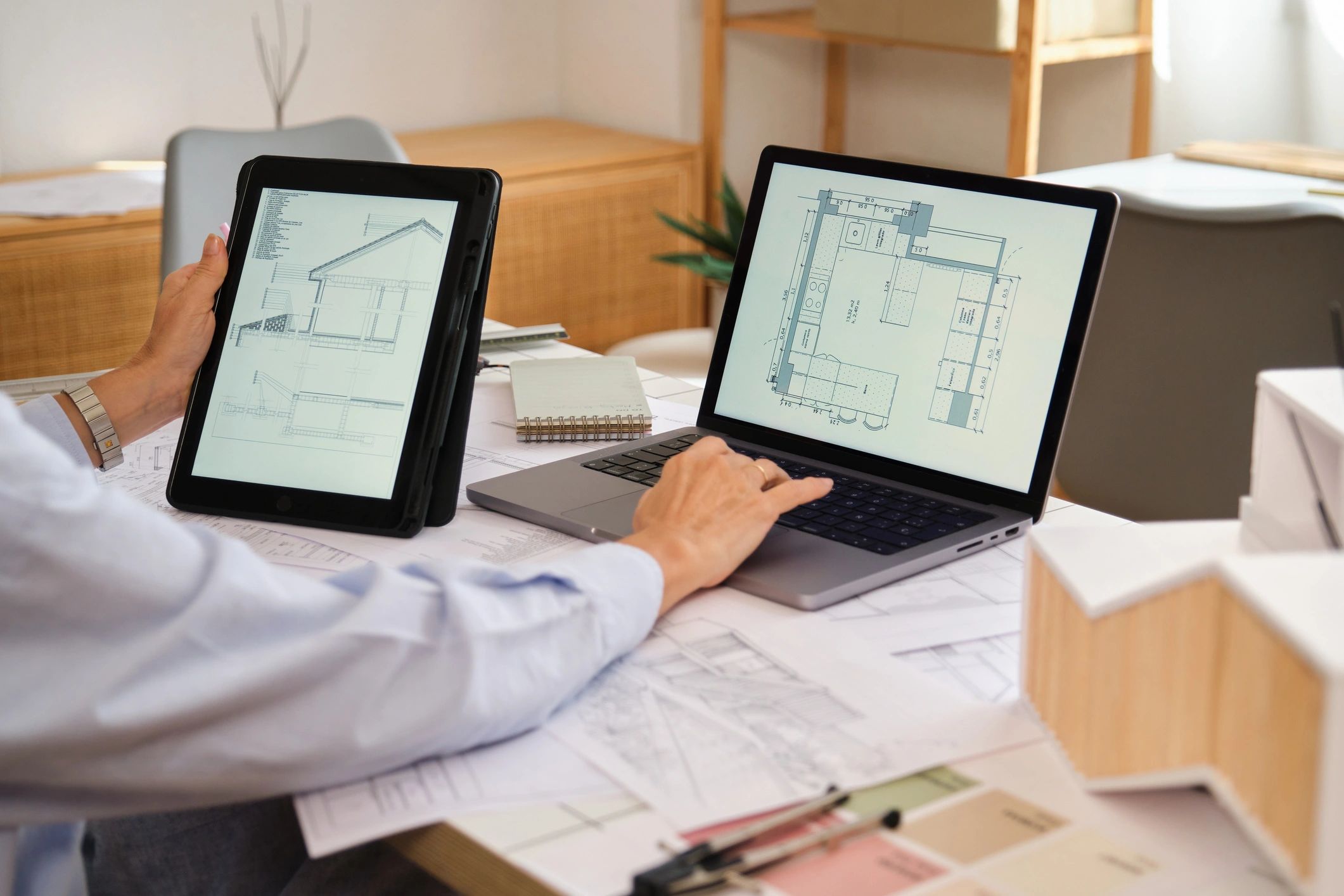 Architect working on plans with a laptop and tablet