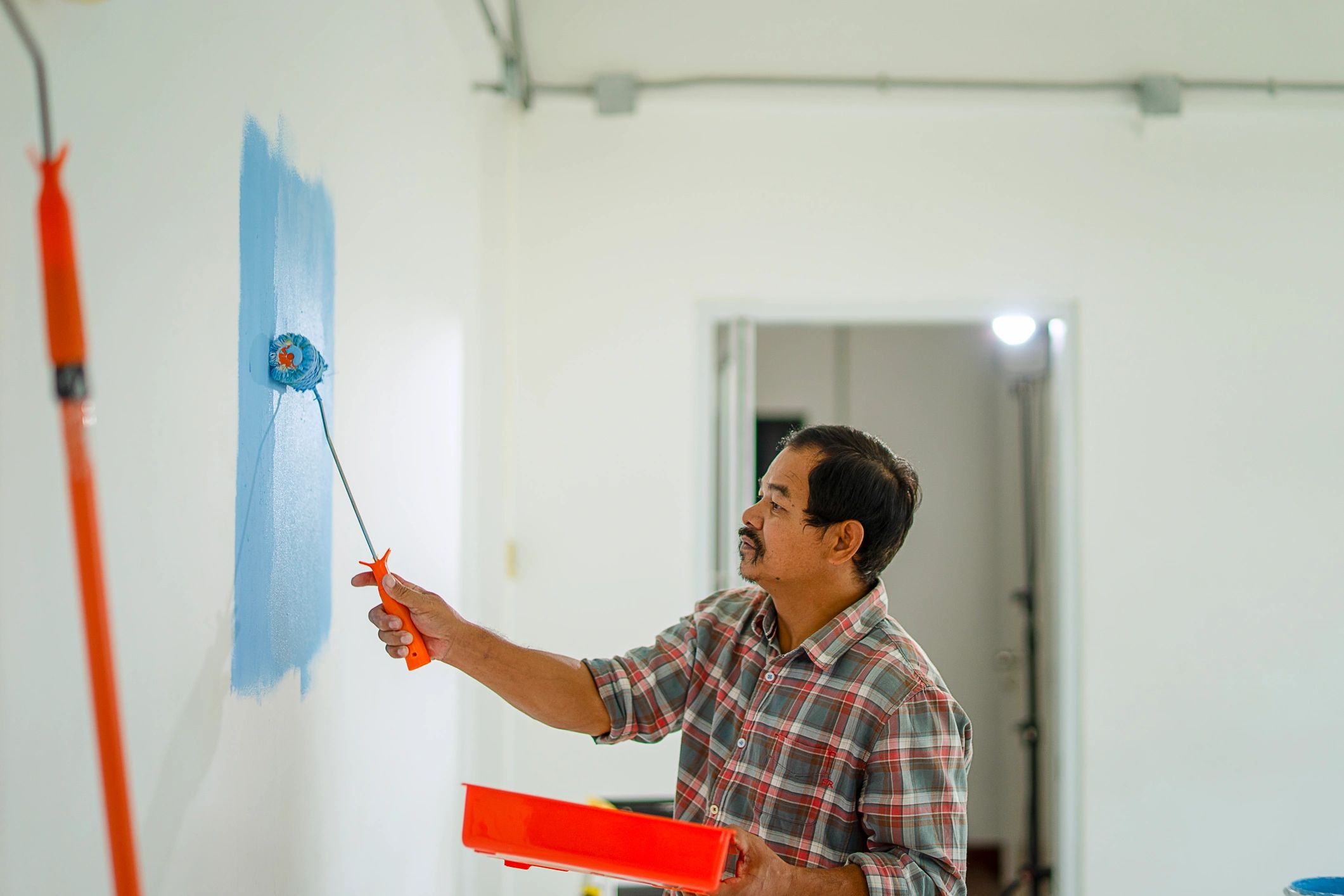 Painter applying paint to an interior wall