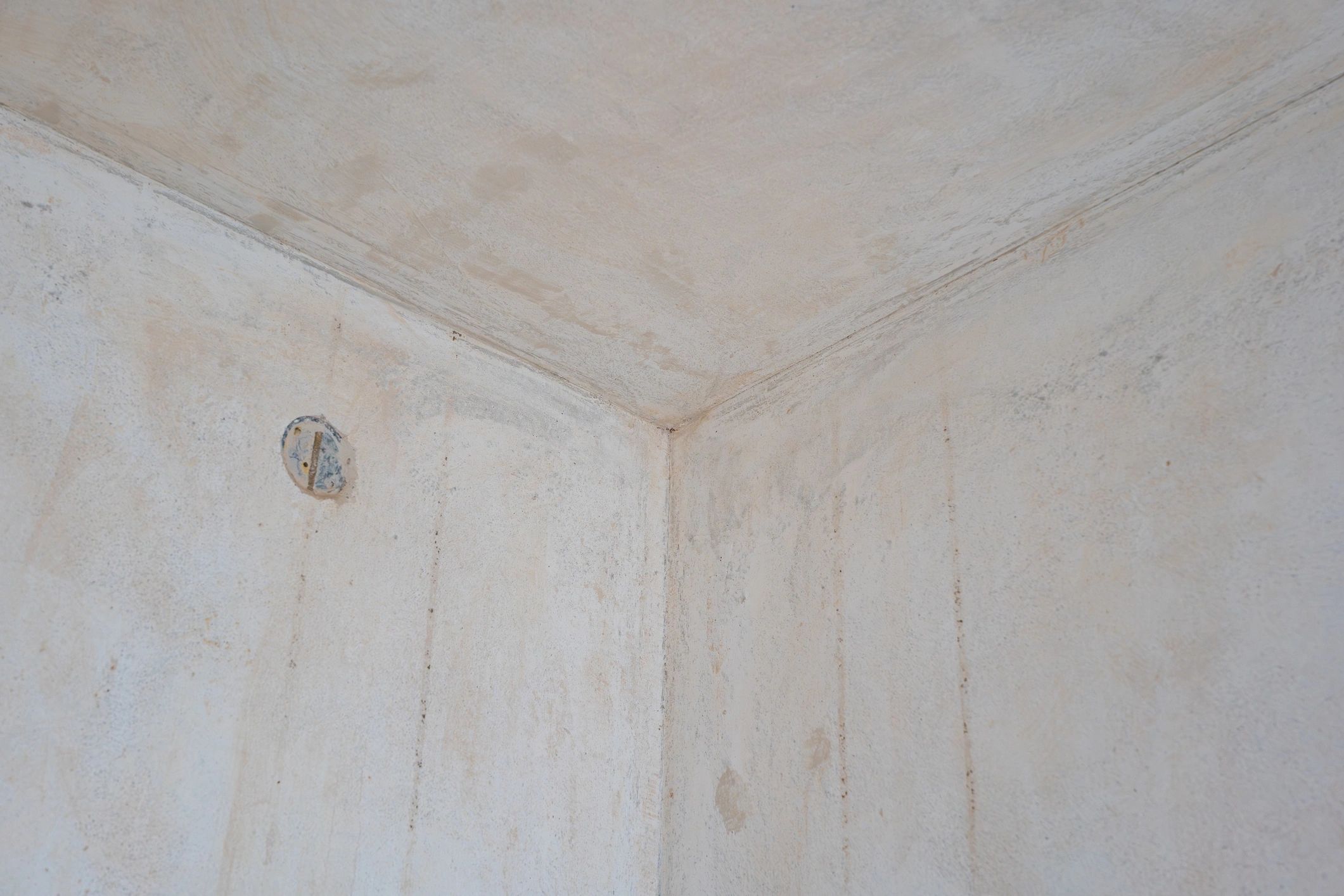 Interior corner under repair with unfinished plaster and electrical junction box